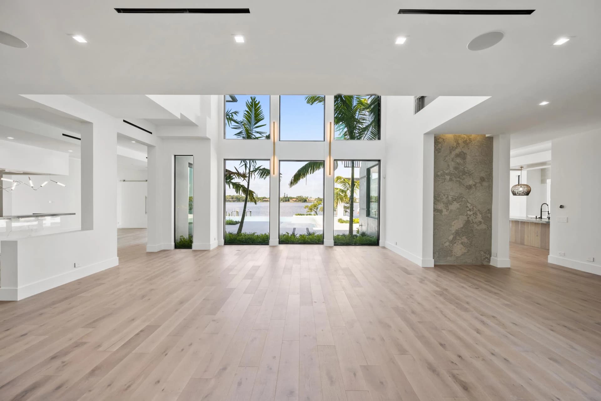 Living room with floor-to-ceiling windows, stone accent wall, and river views