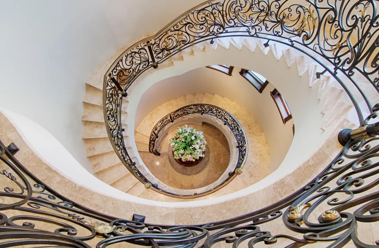 Grand marble staircase with wrought iron railing