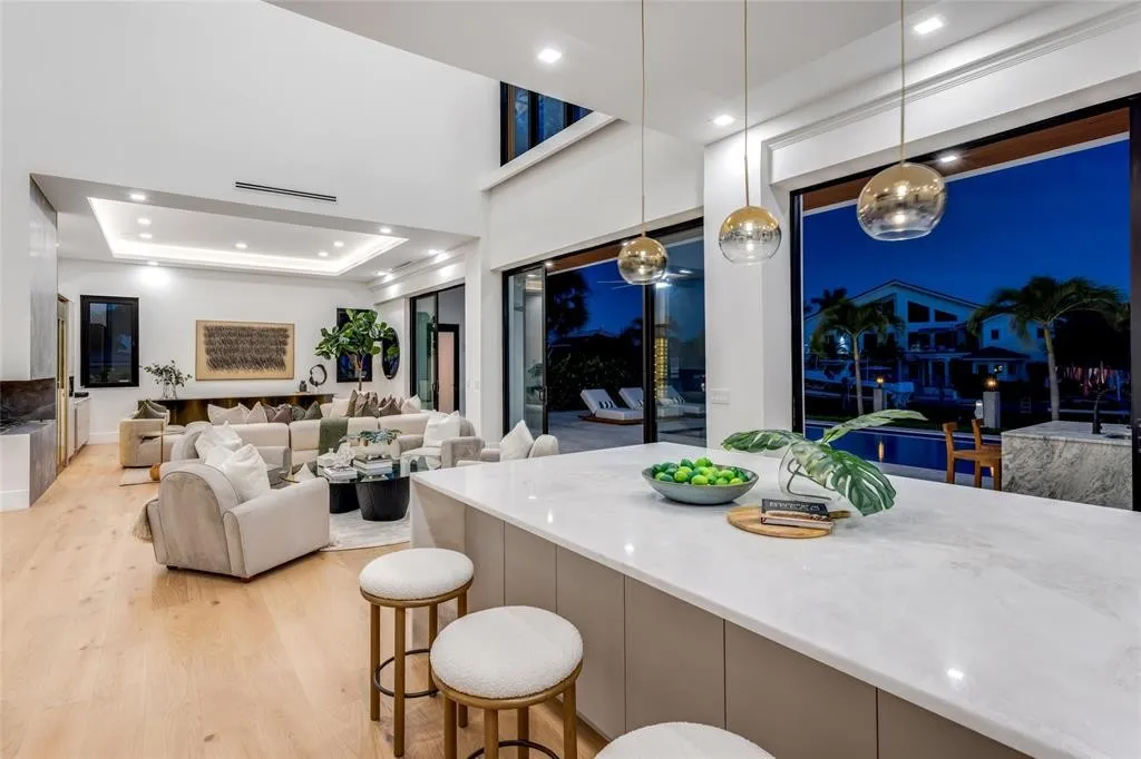 Kitchen detail with Calacatta marble island, gold pendants, marble hood and built-in appliances